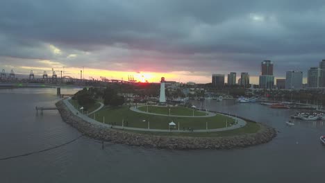 aerial drone footage of light house in the long beach harbor showing downtown buildings