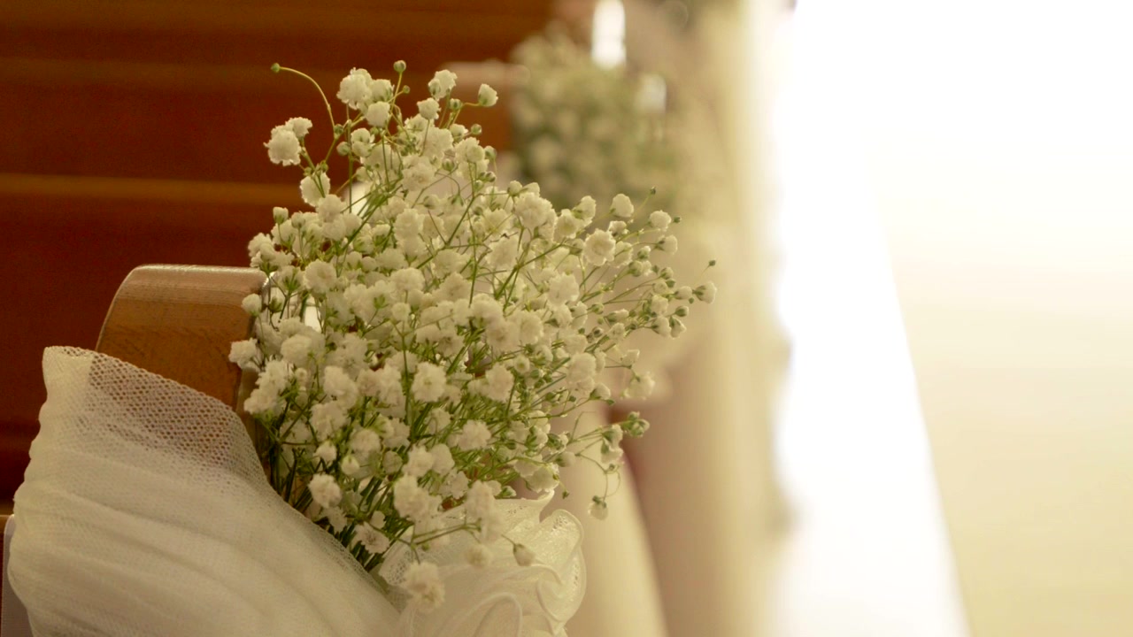 Delicata decorazione di gypsophila attaccata a un banco della chiesa per una cerimonia nuziale