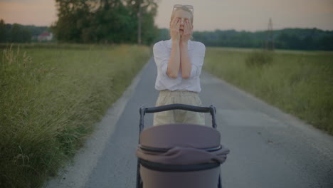 tired woman walking baby in stroller