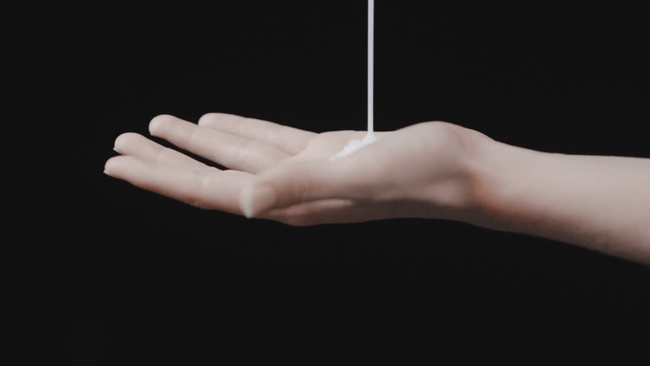 líquido de champú limpiador que cae en la mano sobre negro