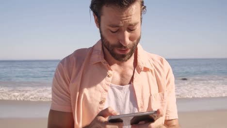 hombre guapo mirando su teléfono móvil
