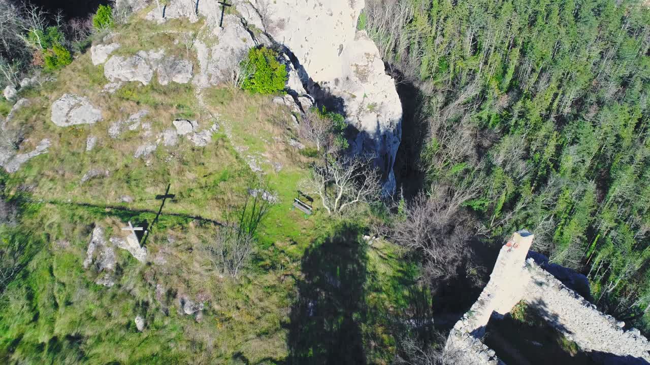 Croci e piccolo edificio abbandonato ai margini di un'imponente montagna, Croazia, vista aerea