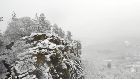 一架无人机在暴风雪中飞过一座岩石的空中景象