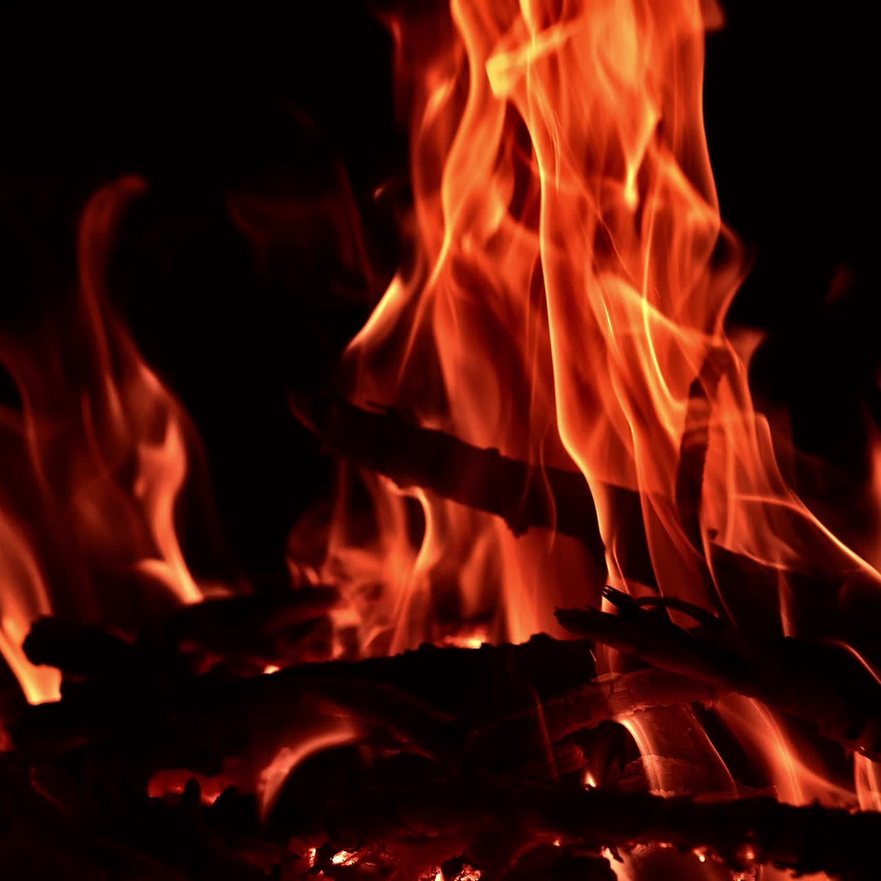 Vista rilassante e tranquilla di un falò che brucia e si muove in modo ipnotico. Pezzi di legno che ardono in una fiamma calda. Primo piano