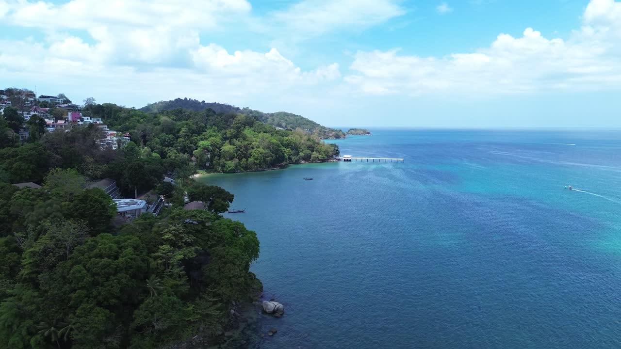 Veduta aerea di lussureggianti colline tropicali coperte da una fitta foresta che conducono a una costa marina calma, creando un suggestivo paesaggio naturale a Patong, Phuket, Thailandia, Sud-est asiatico