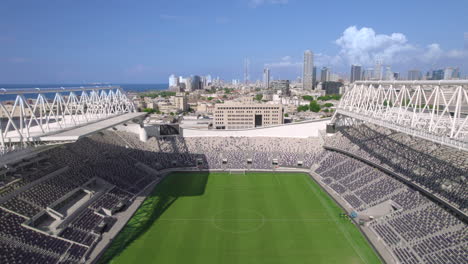 bloomfield football stadium amazing engineering and finest grass, empty from people in jaffa tel aviv, the stadium renovated for 3 years and it is the home of three clubs, city skyline at background