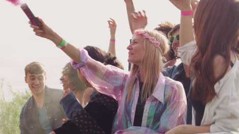 group of young friends dancing behind barrier at outdoor music festival