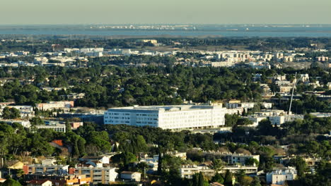 Horizonte-De-Montpellier-Iluminado-Por-El-Sol,-Una-Mezcla-De-Naturaleza-Y-Desarrollo-Urbano-Aéreo.