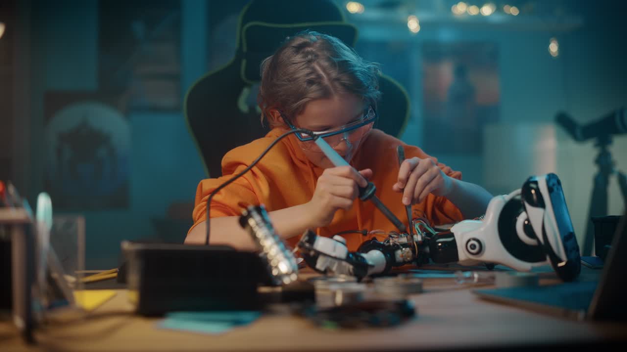 Smart Young Teenage Schoolboy is Studying Electronics and Soldering Wires and Circuit Boards in His Science Hobby Robotics Project. Kid is Working on a Robot in His Room. Education Concept.