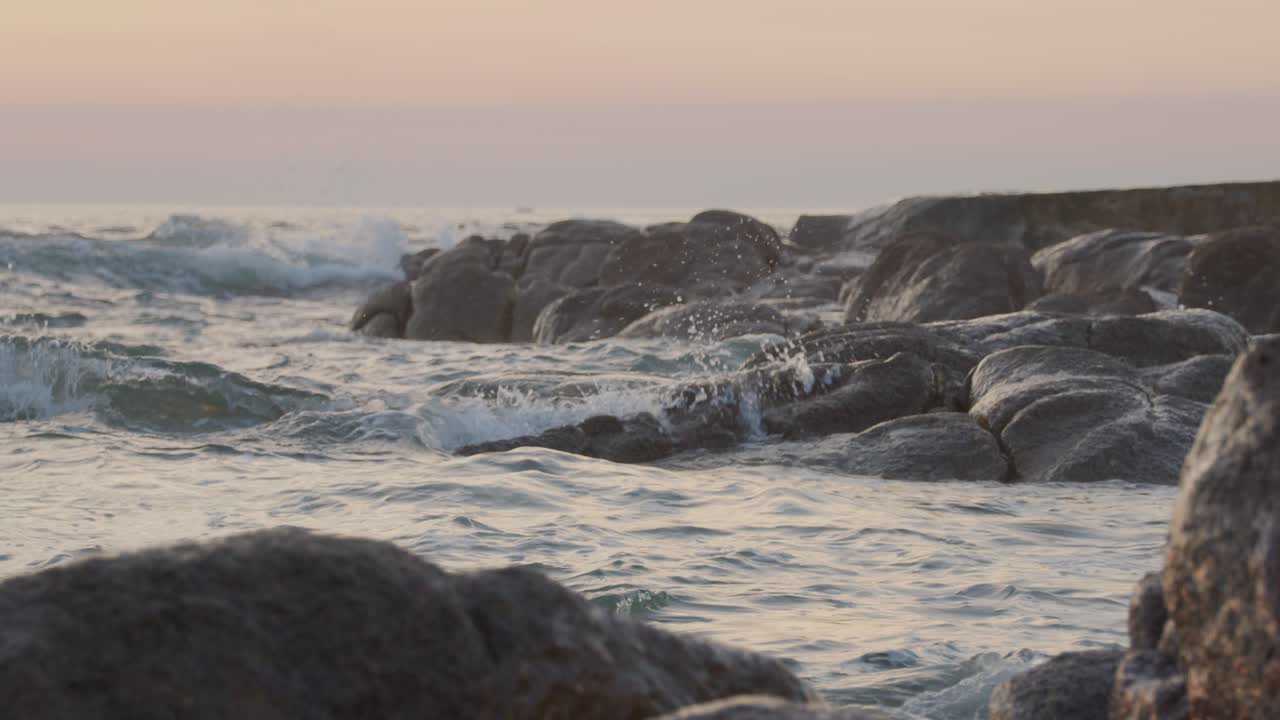 L'acqua si infrange sulle rocce al tramonto su una spiaggia in Portogallo 2