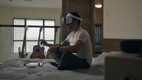 person enjoying virtual reality at home, sitting on bed with vr headset