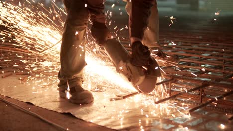 industrial professional worker is cutting metal rebar with a circular saw. construction of a factory, hangar