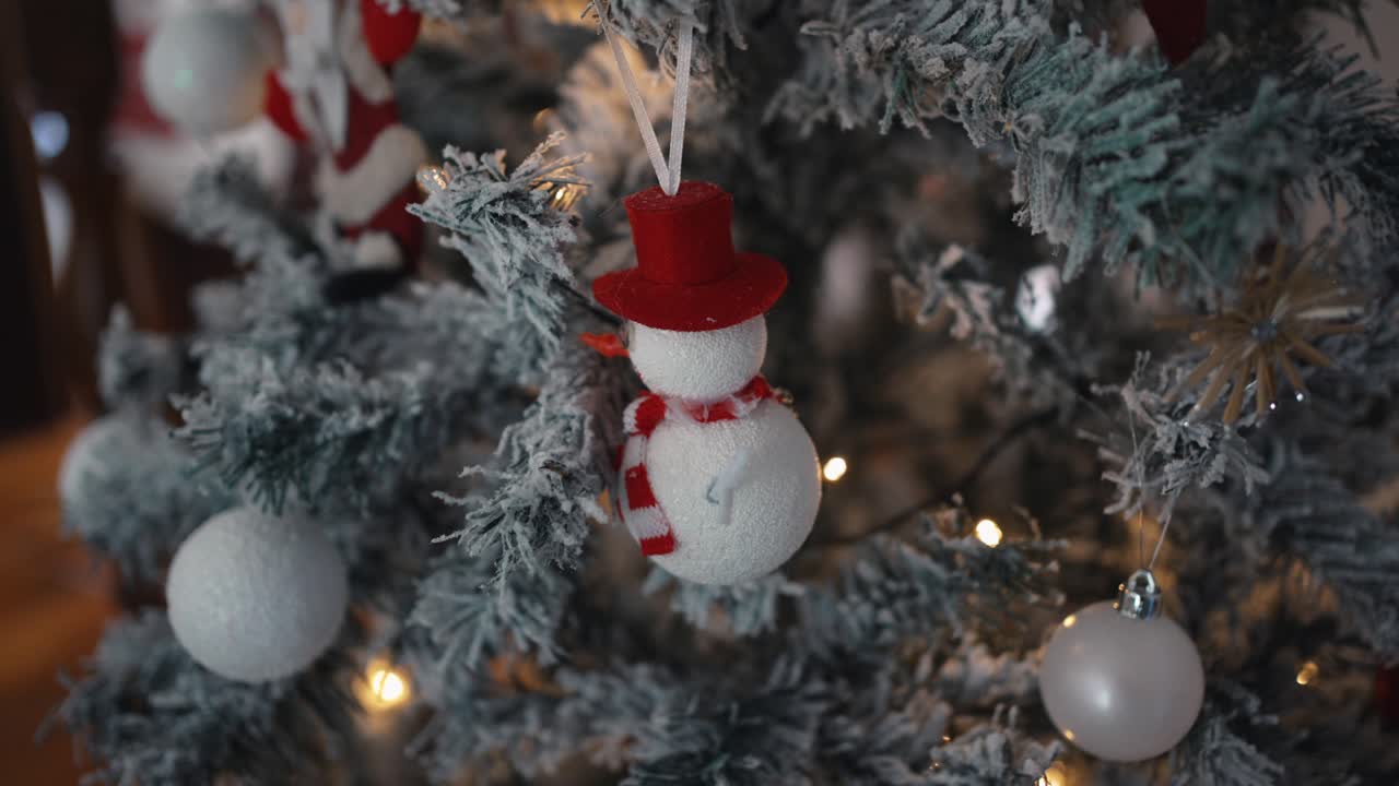 얼어붙은 크리스마스 트리에 있는 스노우맨 장식품