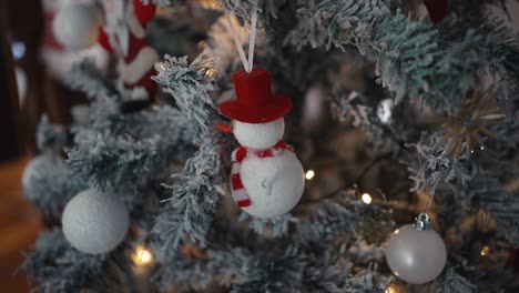 snowman ornament on frosted christmas tree