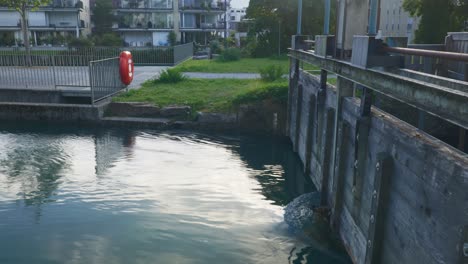 interlaken immersive pov: moving through early morning city streets in switzerland, europe, walking | shaky movement from small bridge to homes on turquoise water front