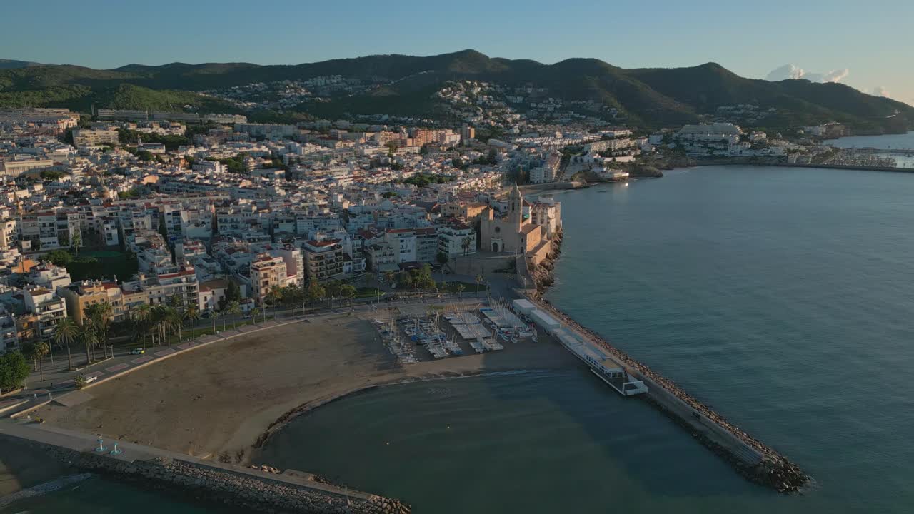 vista aérea sobre el amanecer de sitges, el suroeste de barcelona, el club de yates y la iglesia