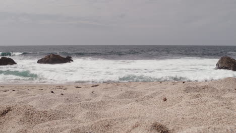 Una-Pequeña-Ola-Enmarcada-Por-Tres-Grandes-Rocas-Rueda-A-Tierra-En-Una-Playa-Del-Norte-De-California