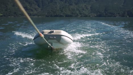 bote inflable remolcado con una cuerda detrás del barco en el océano de nueva zelanda