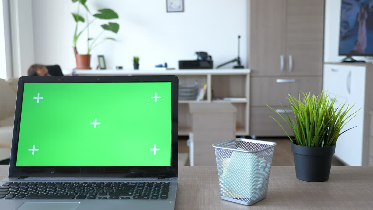 portátil con pantalla verde en una oficina en el hogar