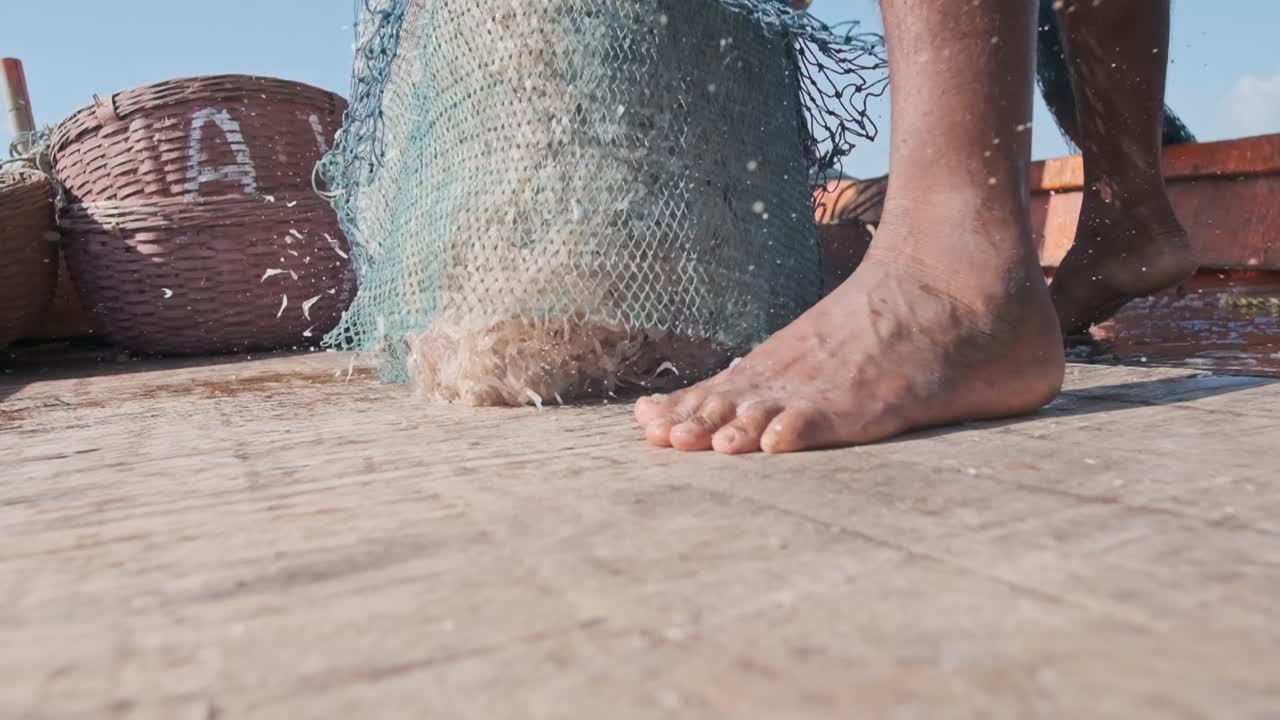 보트 데크 슬로우 모션에 전체 어망을 비우는 인도 어부