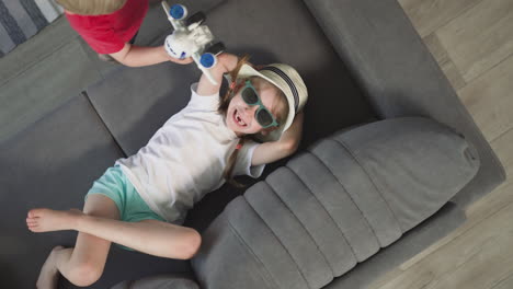 cheerful girl laughs while little boy playing with airplane