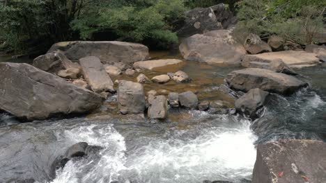 corriente de agua que pasa entre las rocas en la cascada durante el día, cámara lenta