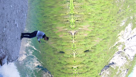 El-Hombre-Toca-El-Agua-En-La-Vibrante-Montaña-Azul-Lago-Di-Braies-En-Dolomitas,-Italia