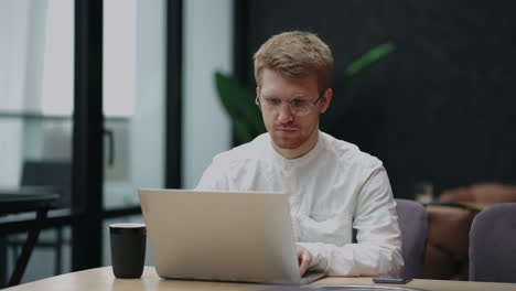 Un-Hombre-Independiente-Está-Trabajando-Con-Un-Cuaderno-En-Una-Cafetería-O-Restaurante-En-El-área-De-Coworking-Durante-El-Día-Para-Trabajar-A-Distancia