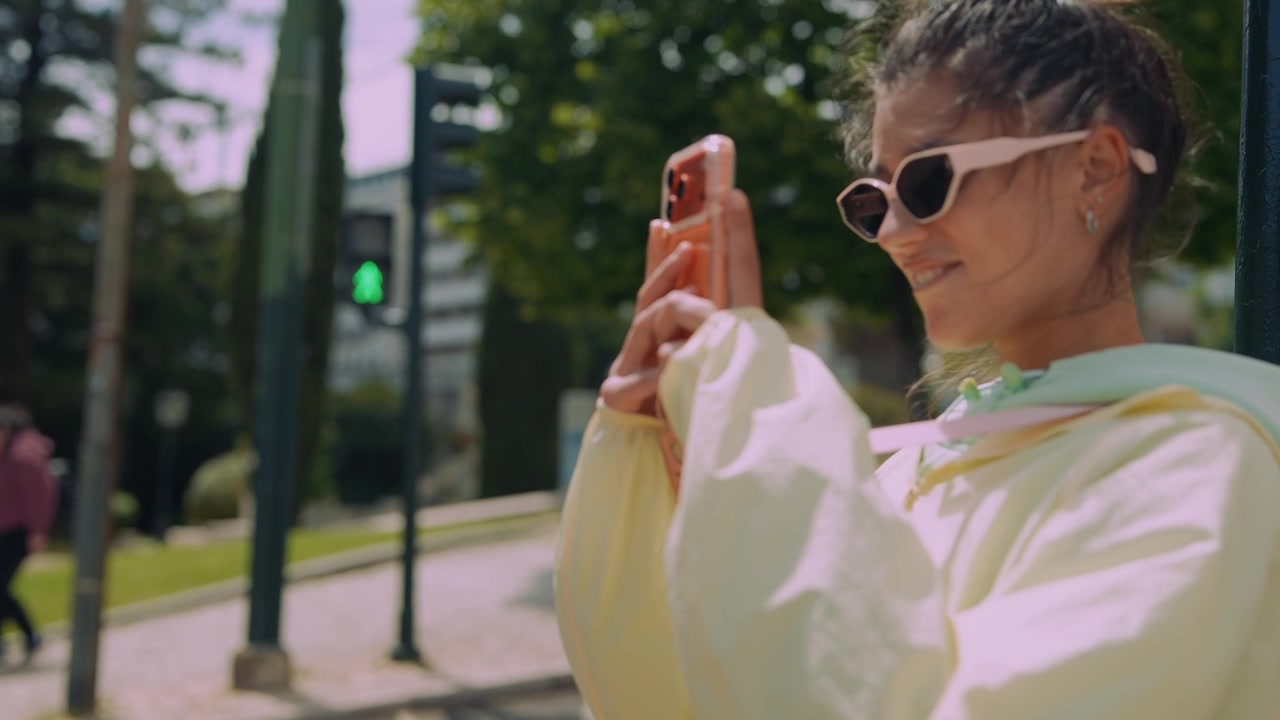 Young Woman Filming with Smartphone on City Street