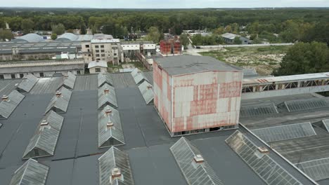 aerial shot of factory complex and rooftop with glass windows, overcast day