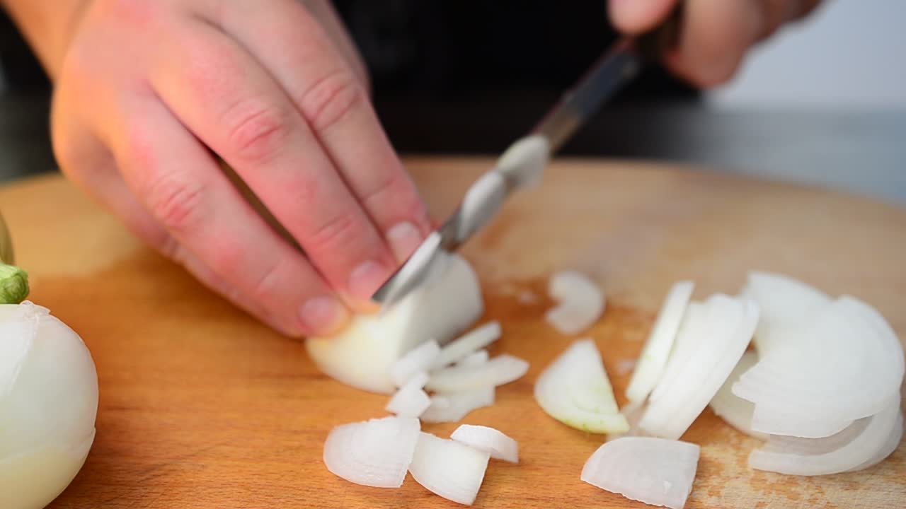 Cooking by the cook. The cook cuts onions
