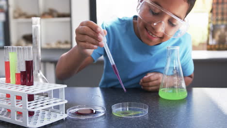 en un aula de laboratorio de una escuela, un joven estudiante afroamericano lleva a cabo un experimento
