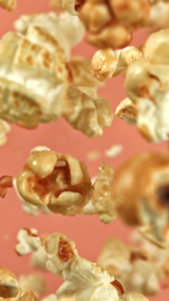 Delicious Popcorn Falling in Slow Motion Against a Pink Background