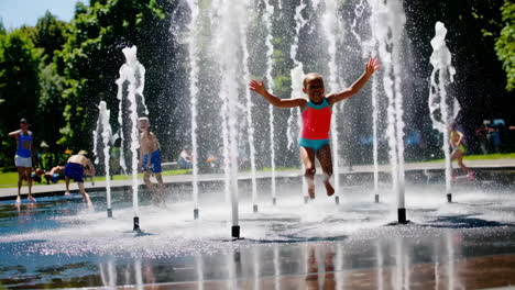 children playing in a water fountain