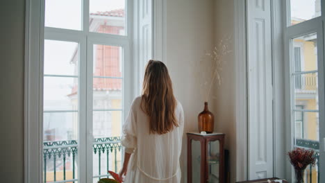 relaxed girl stretching arms at window interior closeup. lady greeting new day