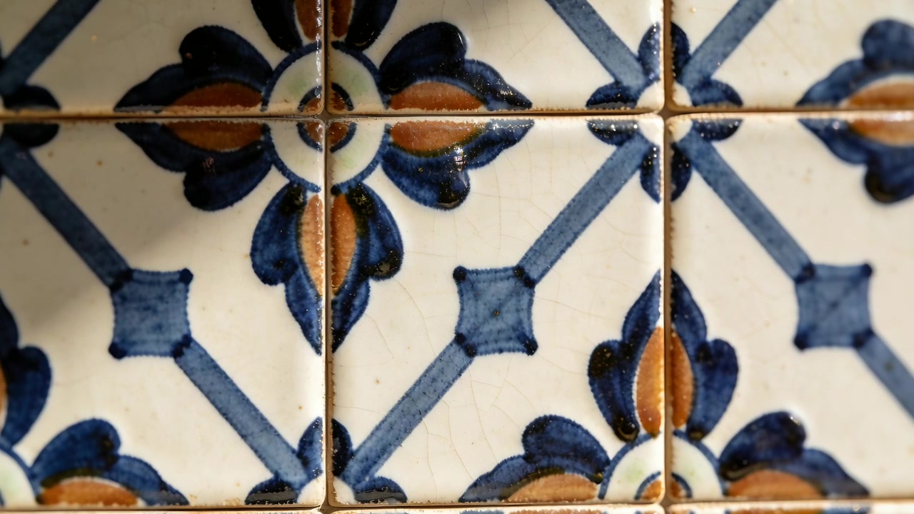 Recentrando a câmera para focar, a luz mudando mostra azulejos esmaltados com motivo azul na cozinha, com craquelado