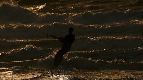 in rays of setting sun, kitesurfer enjoys freedom and excitement of kiteboarding, feeling rush of adrenaline with every movement