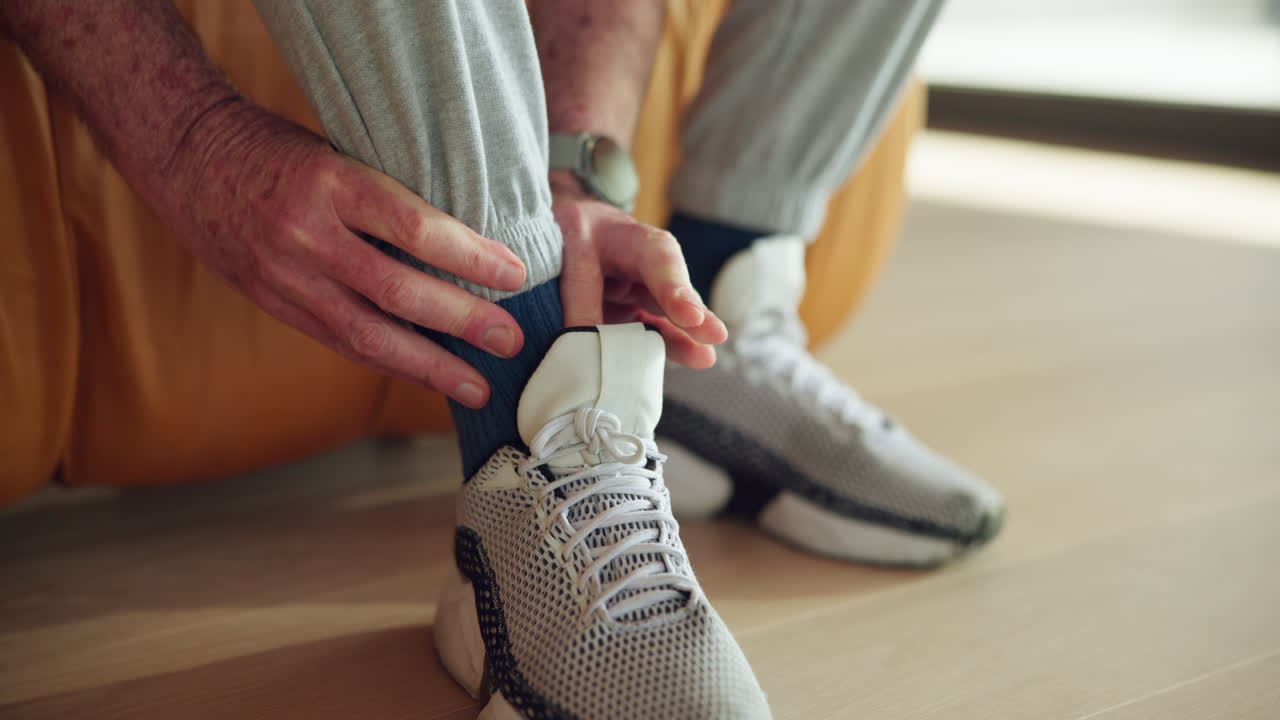 Primo piano di una persona che indossa scarpe da ginnastica e sistema il calzino