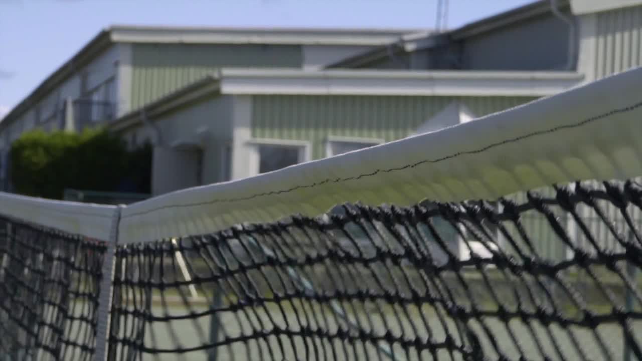 Una pallina da tennis colpisce la rete durante un servizio al rallentatore