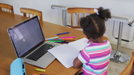 niña afroamericana con escuela en línea en casa usando portátil con espacio para copiar