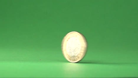 a mexican coin spinning from right to left on a chroma background