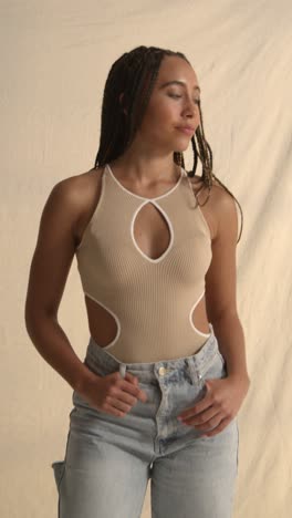 studio portrait shot of young woman with long braided hair against neutral background 3