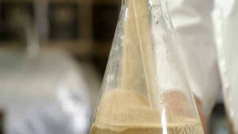 male worker pouring liquor in flask 4k