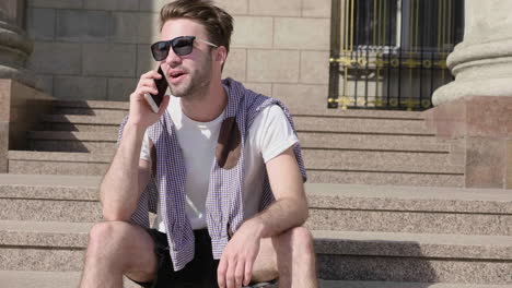 young man talking on phone outside