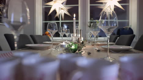 cena de navidad, mesa vacía con copas de vino, velas y luz de navidad, primer plano