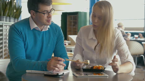 Students-studying-and-eating-sushi-in-cafe