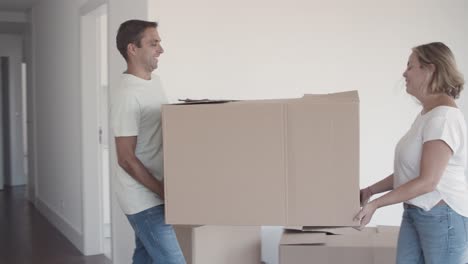 happy couple of parents and two girls moving into apartment