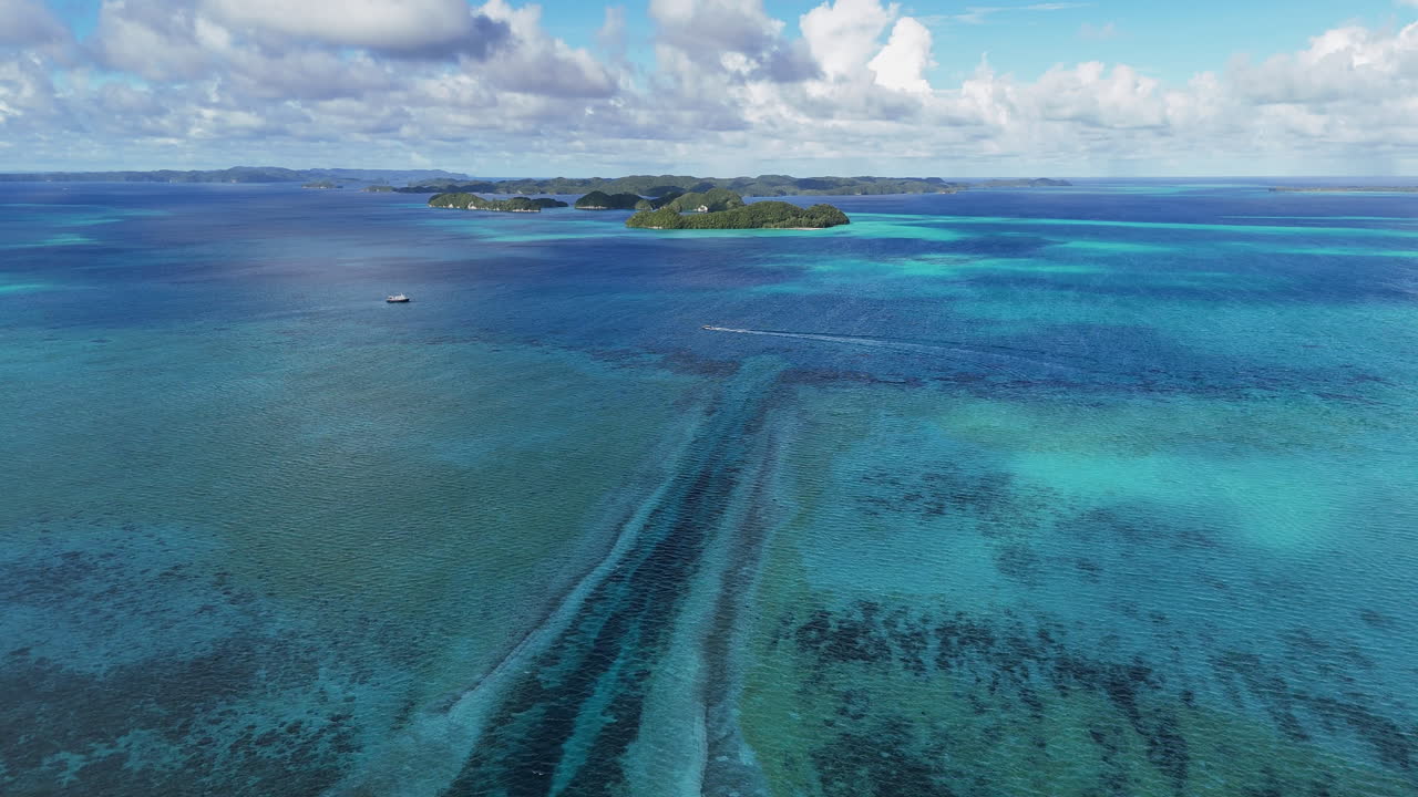 Affascinante filmato drone che sorvola e rivela il vibrante oceano blu e le isole panoramiche di Palau. Ampia inquadratura di barche in acqua in lontananza