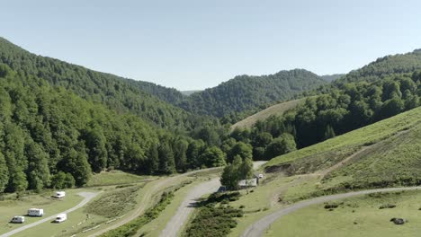 aerial view of mountain valley with campers, roads, and dense forest, col d'iraty, france