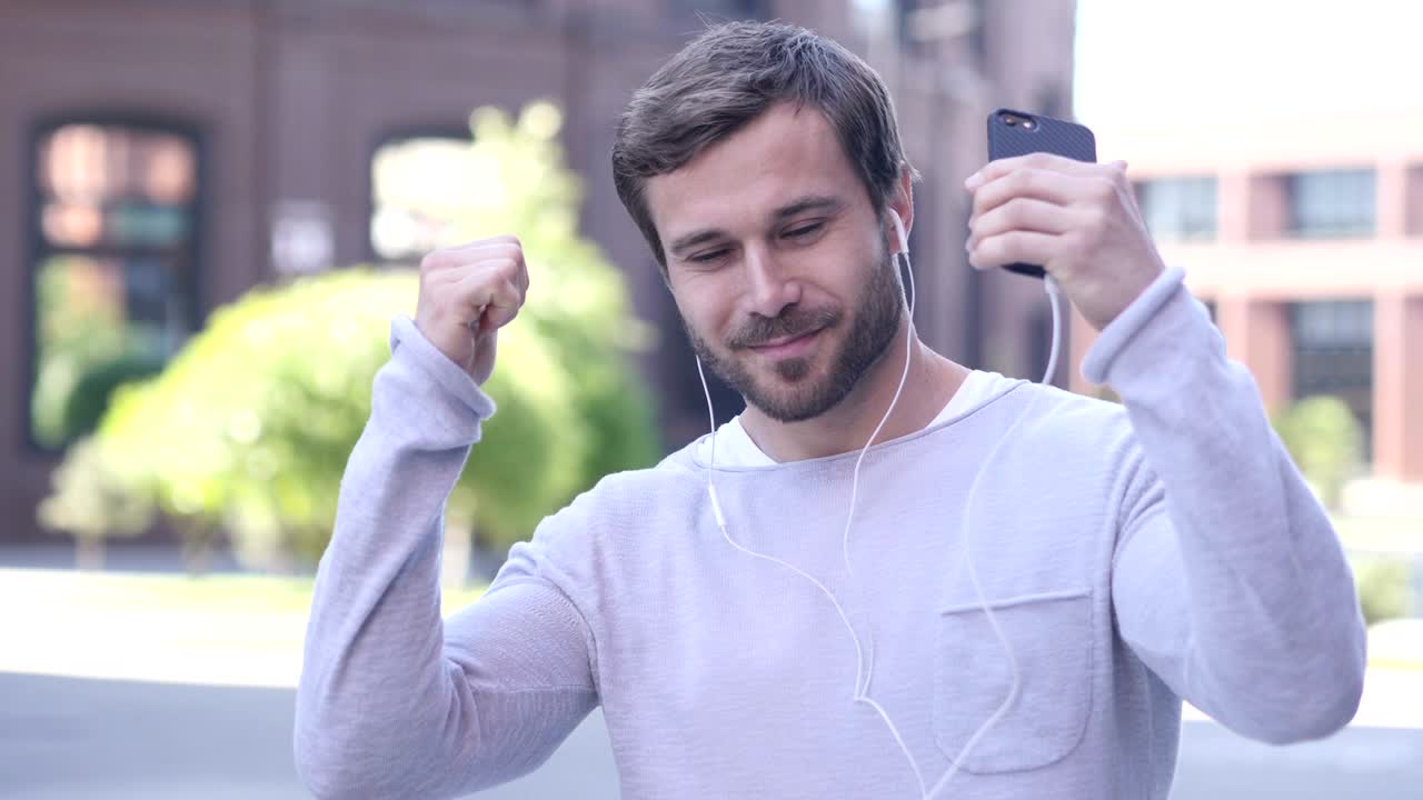 mujer de negocios feliz bailando y escuchando música al aire libre